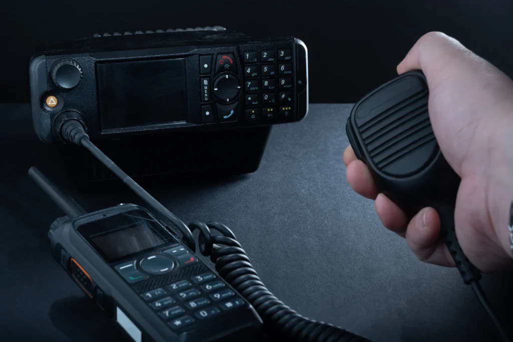2-way radios including a handheld microphone and a base unit, illustrating communication solutions for industries like security and construction.